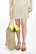 A Young Woman Carrying A Bunch Of Yellow Roses In A Shopping Bag
