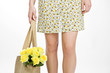 A Young Woman Carrying A Bunch Of Yellow Roses In A Shopping Bag