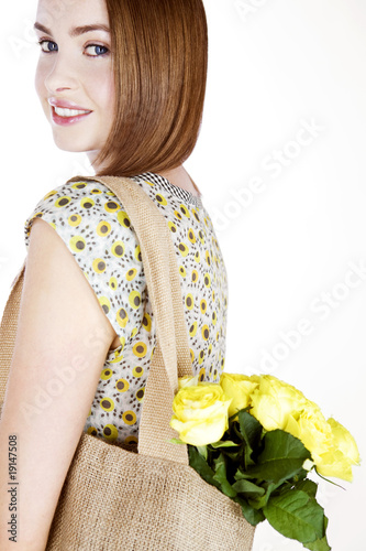 Photo: A Young Woman Carrying A Bunch Of Yellow Roses In A Shopping Bag A Young Woman Carrying A Bunch Of Yellow Roses In A Shopping Bag