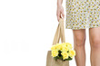 A Young Woman Carrying A Bunch Of Yellow Roses In A Shopping Bag