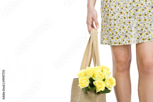 Photo: A Young Woman Carrying A Bunch Of Yellow Roses In A Shopping Bag A Young Woman Carrying A Bunch Of Yellow Roses In A Shopping Bag