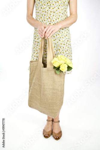 Photo: A Young Woman Carrying A Bunch Of Yellow Roses In A Shopping Bag A Young Woman Carrying A Bunch Of Yellow Roses In A Shopping Bag