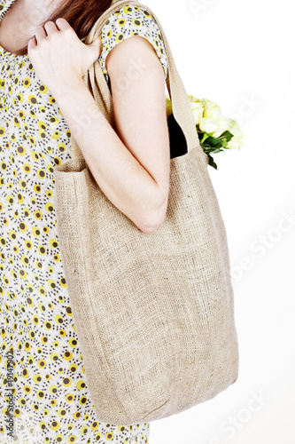 Photo: A Young Woman Carrying A Shopping Bag Over Her Shoulder A Young Woman Carrying A Shopping Bag Over Her Shoulder