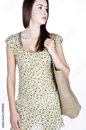 Photo: A Young Woman Carrying A Shopping Bag Over Her Shoulder A Young Woman Carrying A Shopping Bag Over Her Shoulder