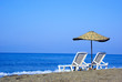 two lounge chairs and parasol on the beach
