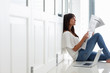 Pretty woman reading a newspaper by the door