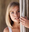 Pensive woman leaning by bamboo sticks