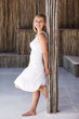 Happy pretty female leaning against a bamboo pillar