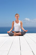 Female meditating on a porch against the sky