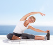 Young woman stretching out while outside on a porch
