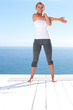 Pretty female stretching her arm while on a porch outdoors