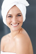Happy female wrapped in towel at bathroom