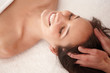 Top view of a happy female receiving a head massage at spa