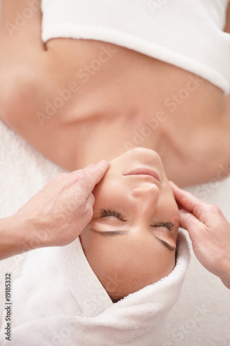 Foto: Top view of a young female enjoying a face massage Top view of a young female enjoying a face massage