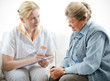 Senior woman is visited  by her doctor or caregiver at home