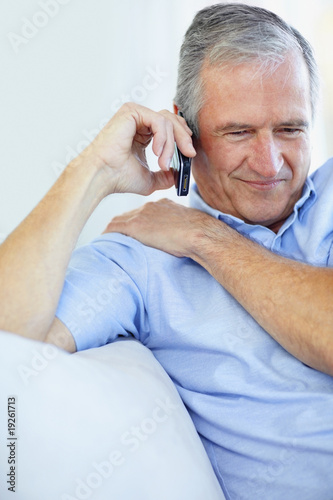 Photo: Happy elderly man conversing over the cellphone Happy elderly man conversing over the cellphone