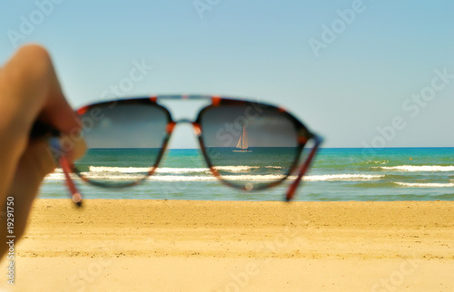 Photo: View of beach beach, sea and yacht over glasses View of beach beach, sea and yacht over glasses