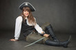 Sexy woman - pirate sits on black background