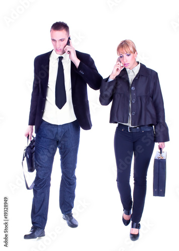 Photo: Busy business people walking and calling on mobile. Busy business people walking and calling on mobile.