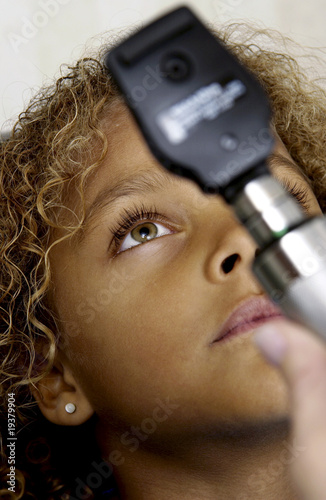 Photo: African American girl getting eye exam African American girl getting eye exam