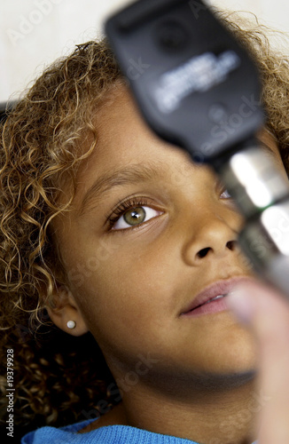 Photo: African American girl getting eye exam African American girl getting eye exam