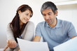 Happy mature couple discussing their finances at home Happy mature couple discussing their finances at home