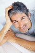 Closeup portrait of smiling man lying on sofa