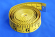 A coiled-like measuring tape isolated on blue background