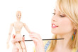 happy teenage girl with wooden model dummy