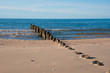Remains of old wooden pier in the sand of Baltic Sea coast