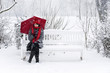 Frau im Schnee auf einer Bank