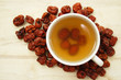 Foto: A cup of chinese red date tea with pitted dates around the cup A cup of chinese red date tea with pitted dates around the cup