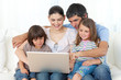 Jolly family using a laptop on the sofa Jolly family using a laptop on the sofa
