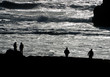 Silhouetted figures at Ocean's edge