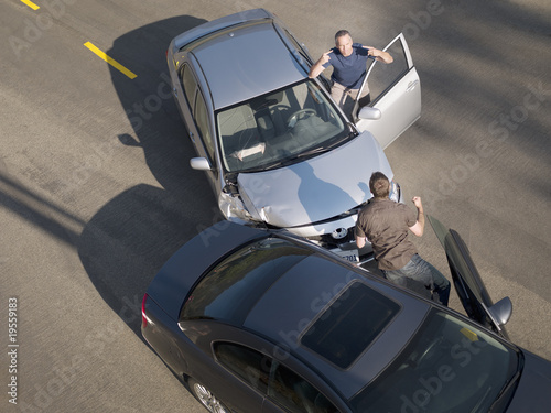 Photo: Two men arguing about damage in car collision Two men arguing about damage in car collision