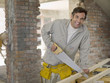 Man sawing wood at construction site
