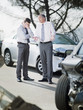 Two businessmen arguing about damaged cars
