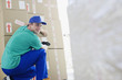 Delivery man taping cardboard boxes in warehouse