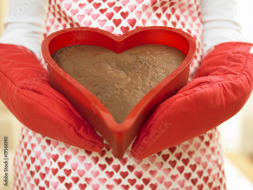 Photo: Close up of woman holding heart-shaped cake Close up of woman holding heart-shaped cake
