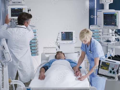 Foto: Doctor and nurse attending patient in intensive care Doctor and nurse attending patient in intensive care