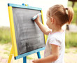Child drawing with chalk at the blackboard