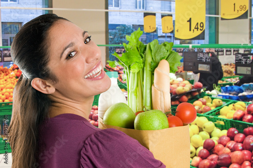 Photo: Young woman doing shopping in a supermarket Young woman doing shopping in a supermarket