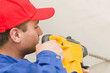 A young handyman holding in his hand a big drill