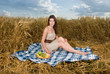 Beautiful slavonic girl on picnic in wheat field