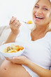 Attractive mature woman enjoying her breakfast of fresh fruits