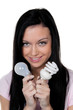 Frau mit Energie Sparlampe. Energielampe und Glühlampe