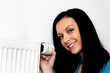Foto: Frau mit Heizkörper und Thermostat einer Heizung Frau mit Heizkörper und Thermostat einer Heizung