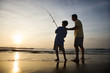 Photo: Man and young boy fishing in surf Man and young boy fishing in surf