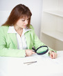 Beautiful girl works with drawing by means of magnifier Beautiful girl works with drawing by means of magnifier