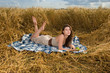 Beautiful slavonic girl on picnic in wheat field with apple